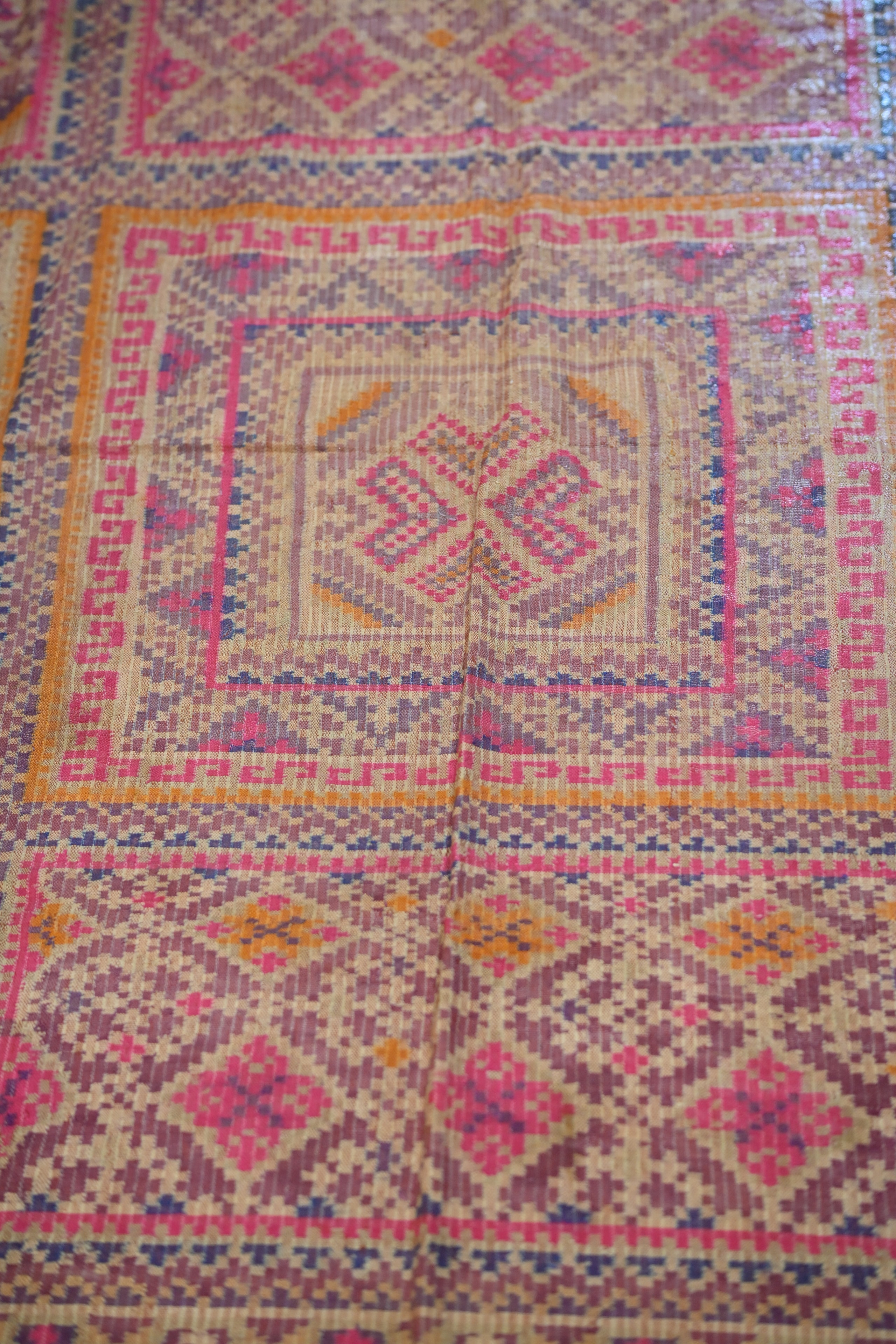 Close-up of handwoven textile with pink diamond pattern