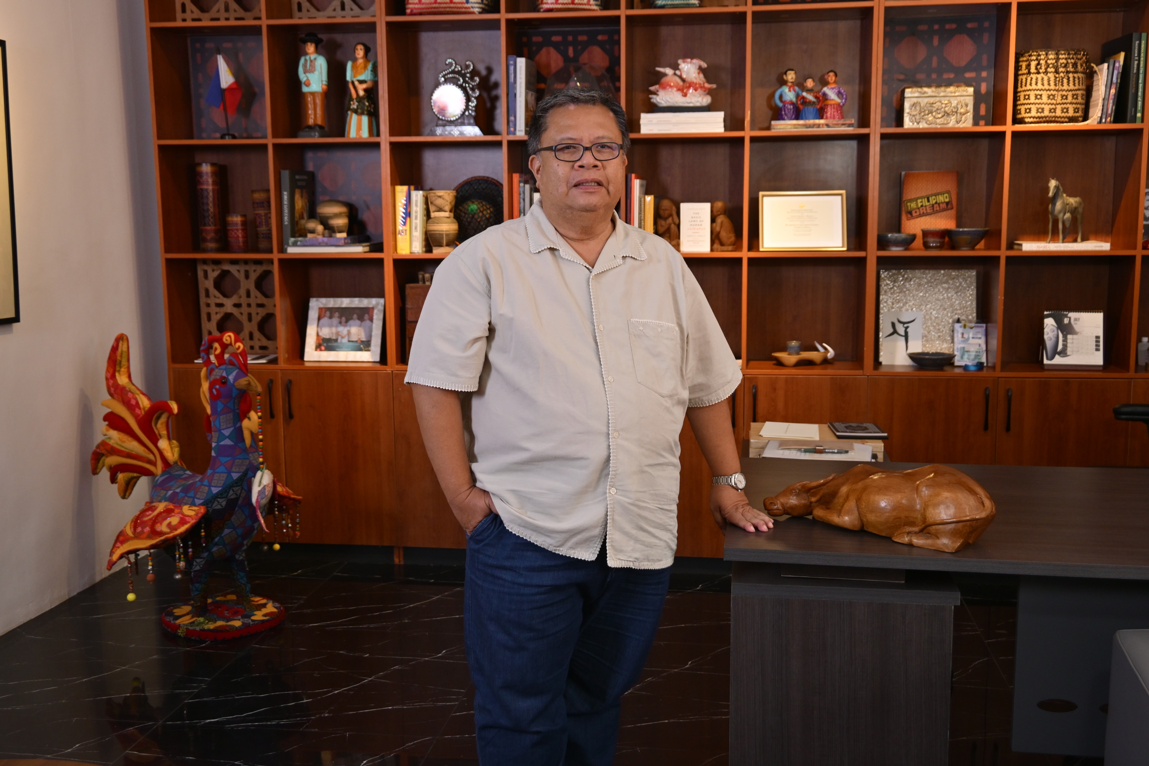 Al Valenciano standing beside a carabao sculpture at the Likhang Filipino exhibit