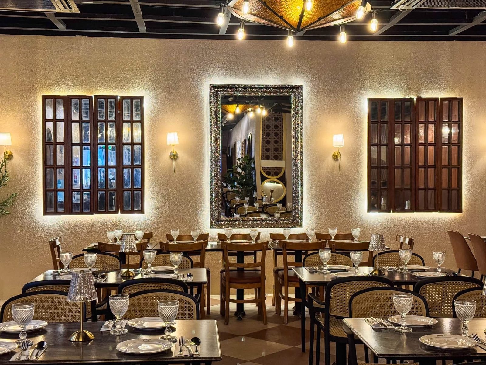 Tatung's restaurant dining room with warm lighting, cane chairs, and capiz shell chandelier